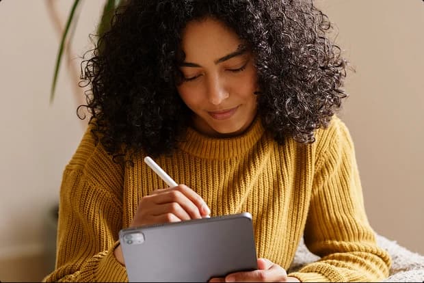 Mulher com cabelo cacheado trabalhando no laptop